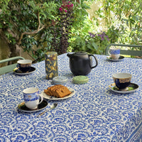 Table ronde habillée de la nappe Lehar en terrasse, bordure imprimée dense visible au premier plan