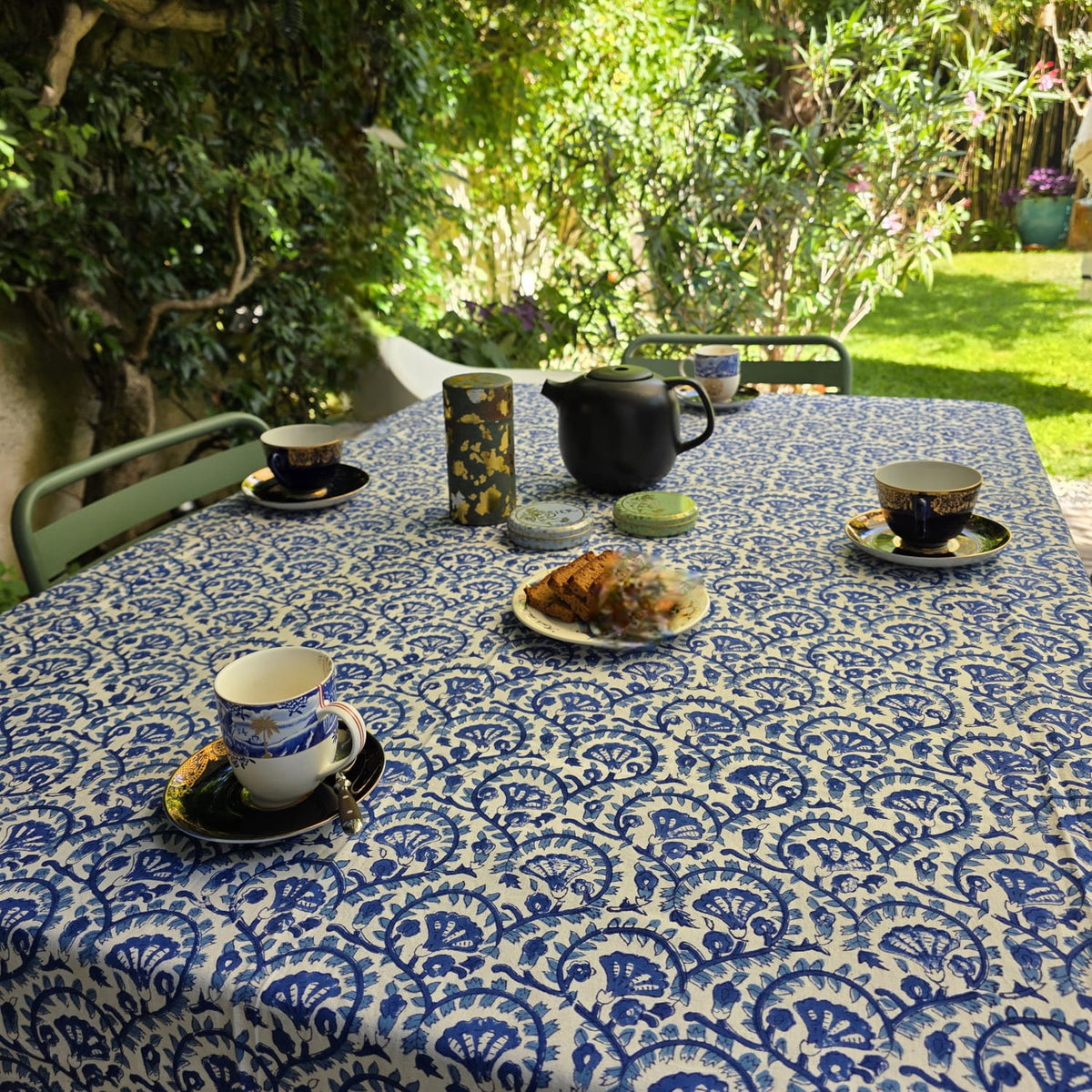 Nappe Lehar sur une table dressée au jardin, vue large sous les arbres