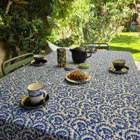 Nappe Lehar sur une table dressée au jardin, vue large sous les arbres