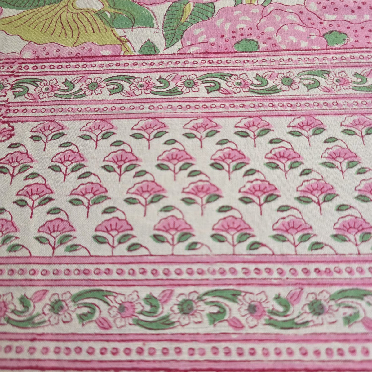 Détail du coton imprimé au bloc de bois : le semis de fleurs roses de la bordure de la nappe Pallavi