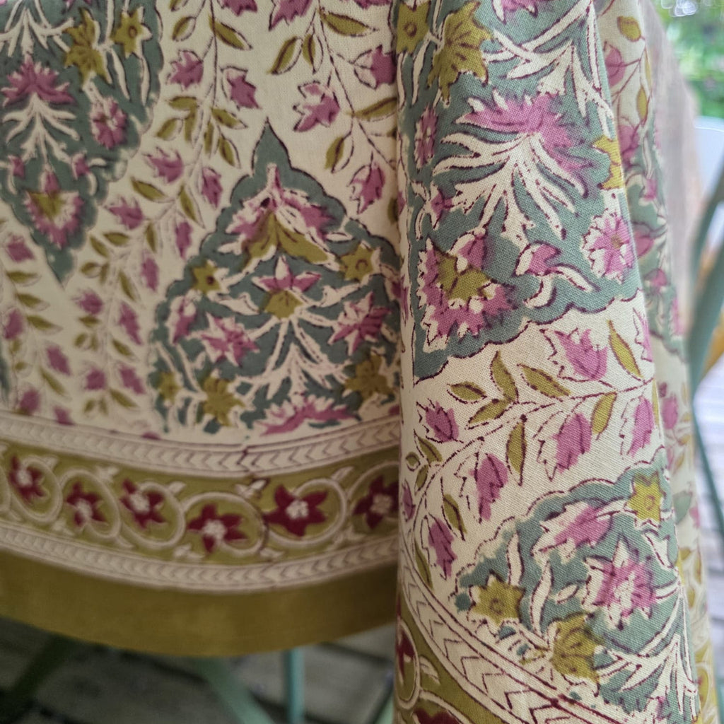 Détail du blockprint de la nappe Tulsi : médaillon en ogive, fleurs rose ancien, feuillage sauge et bordure moutarde